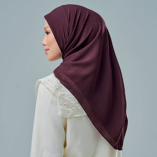 TudungPeople Nisa 2.0 Signatures velvet hijab in prune color, shown folded with smooth fabric and elegant texture.