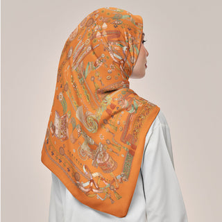 Warm orange print from TudungPeople's Atelier collection, featuring a stylish square design with vibrant, eye-catching colors.
