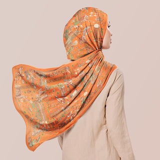 TudungPeople Atelier warm orange print fabric, showcasing vibrant color and detailed design for stylish headscarves.