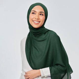 TudungPeople Suri in Verdant signature hijab displayed on a mannequin with vibrant green fabric and detailed stitching.